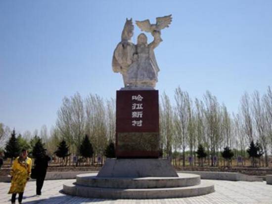哈拉新村的莫日根广场和主题雕塑，基座上有"哈拉新村"字样