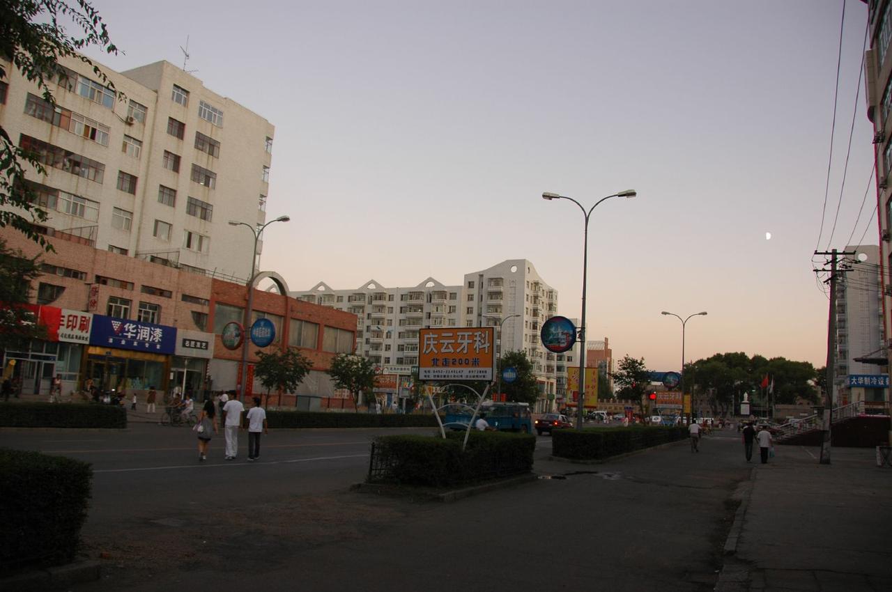 齐齐哈尔市区街景，可见高层建筑与低层历史建筑的混合并存