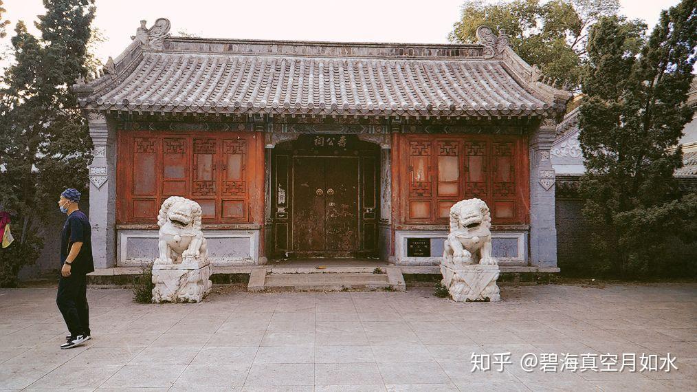 寿公祠山门正面,青砖灰瓦三合院,门前石狮分列,屋檐下悬黑底金字"寿公祠"匾额