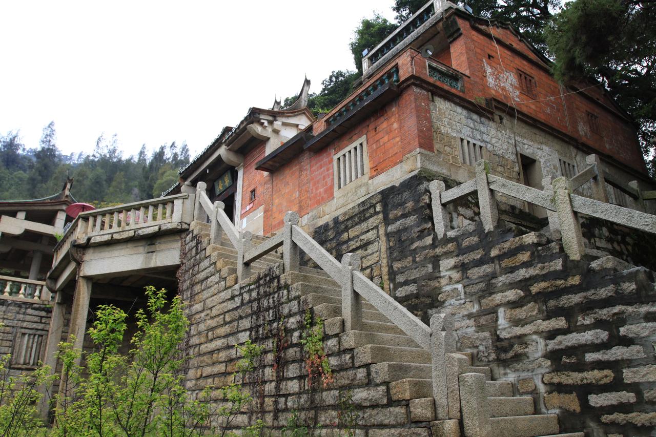 草庵石构建筑侧面：不规则块石砌筑的墙体与山崖的关系