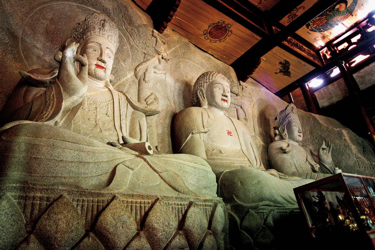 南天寺自在佛殿内依山崖雕刻的西方三圣石像