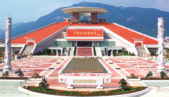 博物馆全景:在西湖边远眺,红砖建筑与金色和平莲倒映在广场水池中