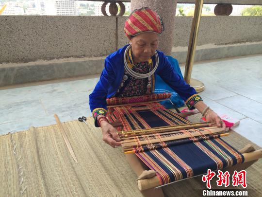 黎族阿婆坐在腰织机前织黎锦