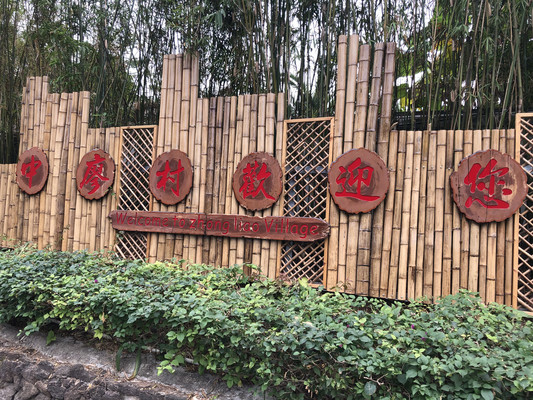 "中廖村欢迎您"入口标识,竹篱笆和木牌是旅游化改造的典型视觉语言