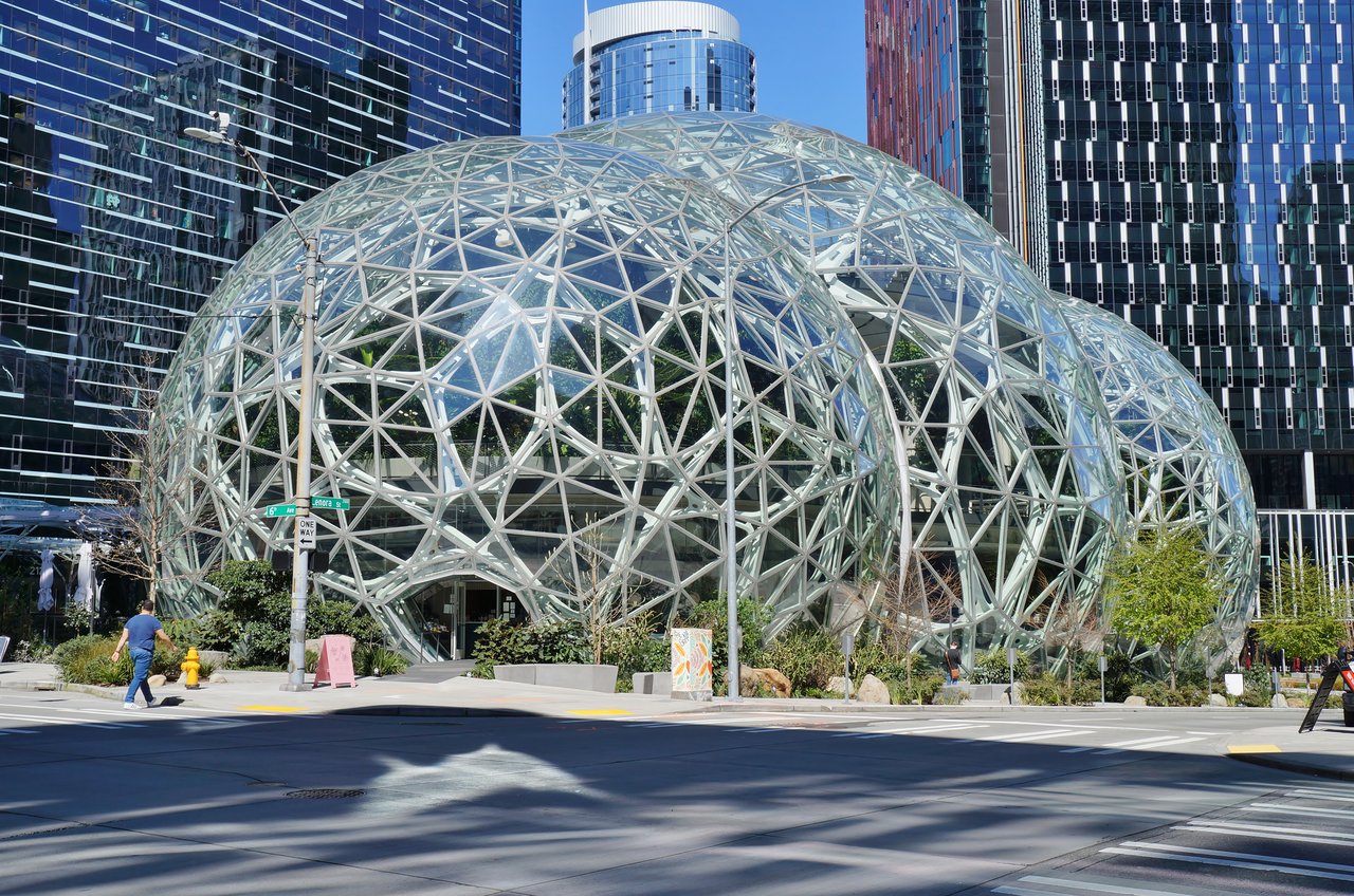 从 6th Avenue 看 Amazon Spheres 与 Day 1 Tower 同框：三个交错玻璃球体在前，37 层办公塔在后