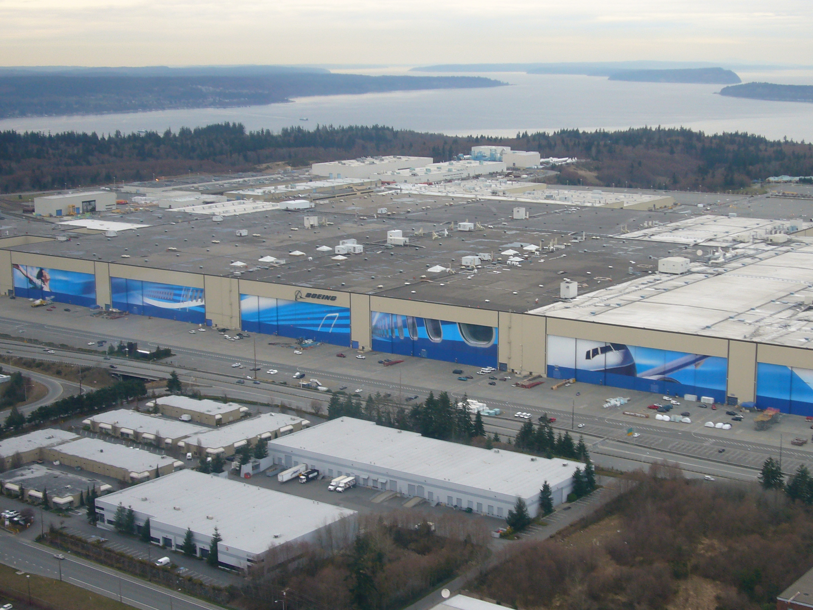 从空中看 Boeing Everett 主装配厂房，停机坪上有多架交付前的 widebody