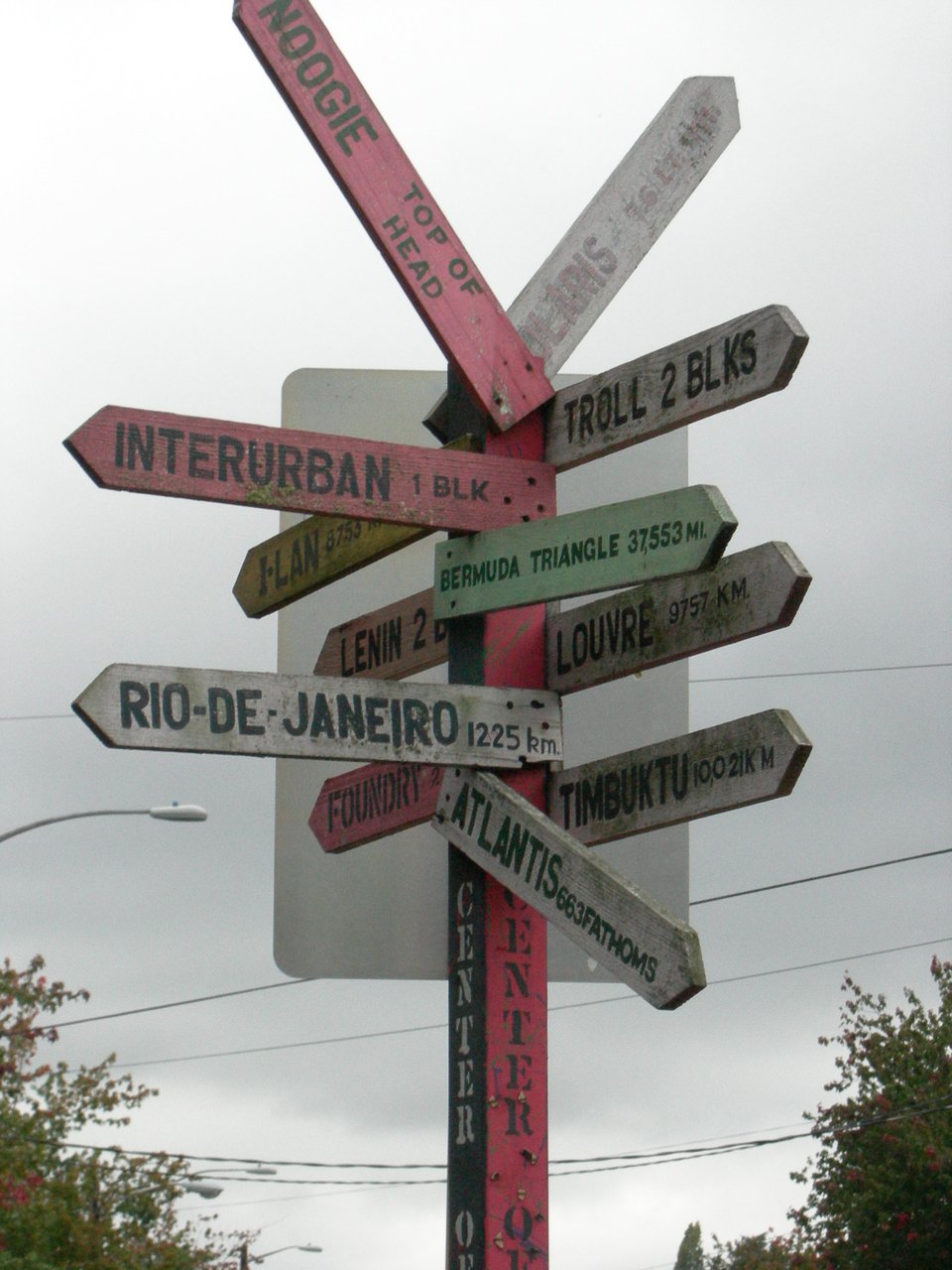Center of the Universe 路标在 N 35th Street 与 Fremont Avenue 路口，钢柱上挂多组铁箭头指向 Lenin、Troll、Atlantis、Louvre 等地