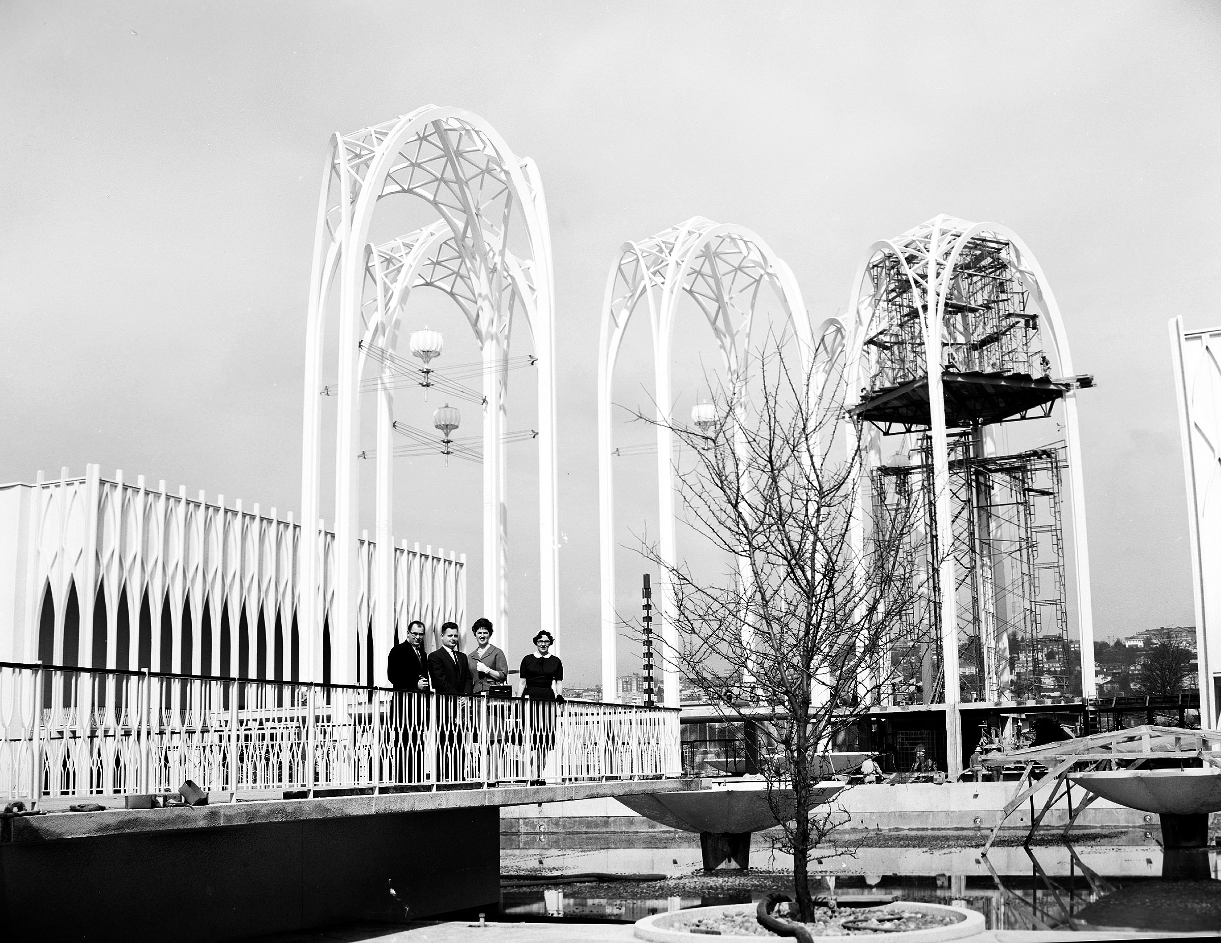 1962 年 World's Fair 期间的 United States Science Pavilion：拱塔下方水池与世博访客