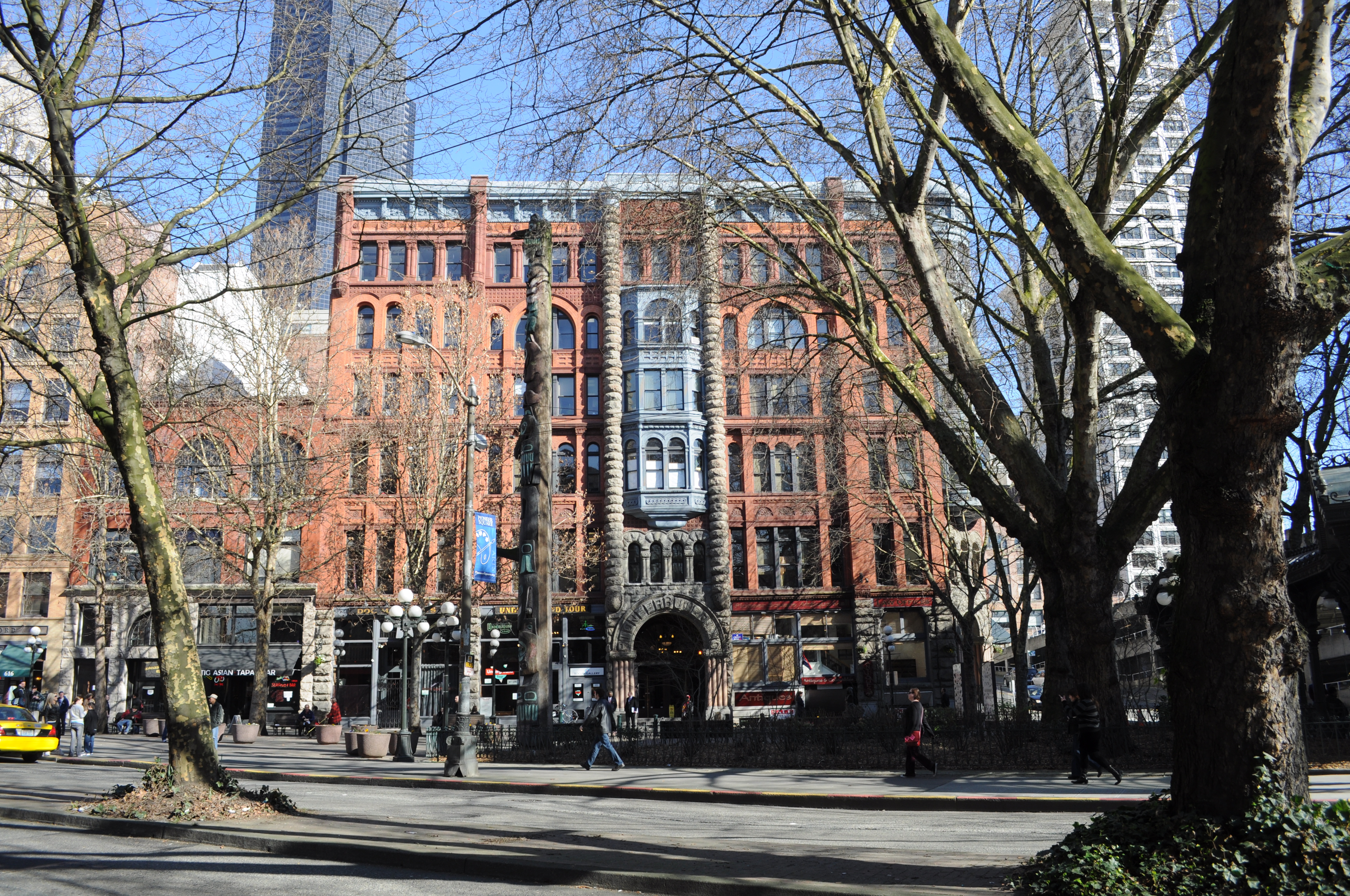 Pioneer Building 立面：红砖加灰色拉毛石、半圆拱窗、垂直壁柱与水平腰线交错的方格构图