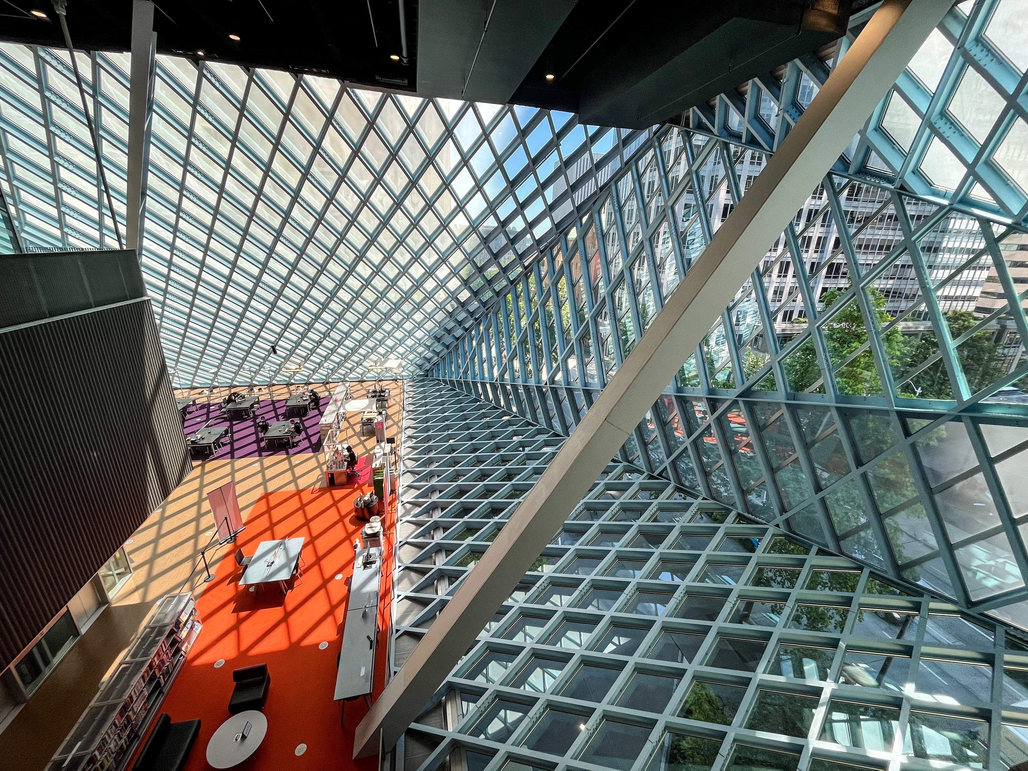 Seattle Central Library 内部斜玻璃幕墙与饱和红色 Meeting 平台的对照
