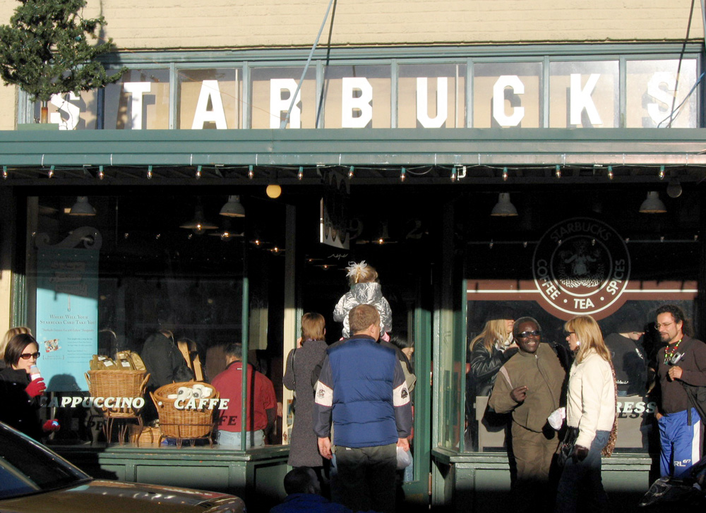 1912 Pike Place 的 Starbucks 店面，挂着旧版棕色美人鱼商标