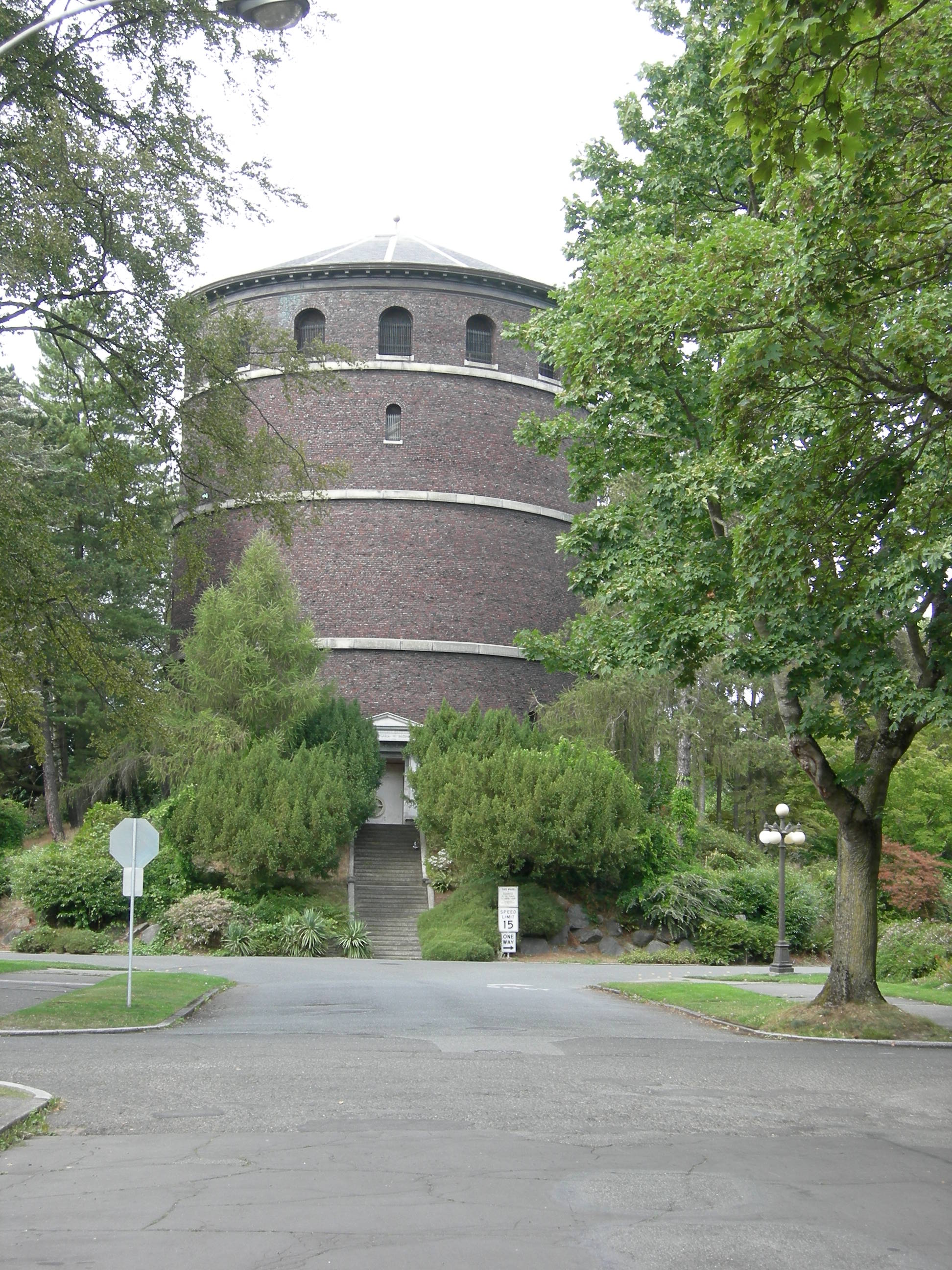 Volunteer Park 水塔正立面：红砖、白色檐口、锥形铜顶与顶端的圆球收尾