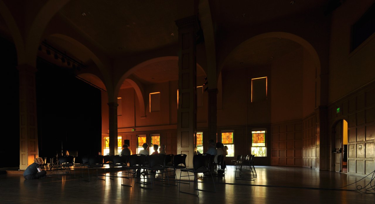 Chapel Performance Space 内部全景：木地板、四根承重柱、彩色玻璃高窗、舞台位置