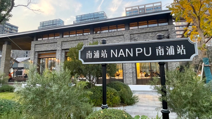 南浦站保留站台，青砖拱廊和木结构雨棚下可见保留铁轨和站牌