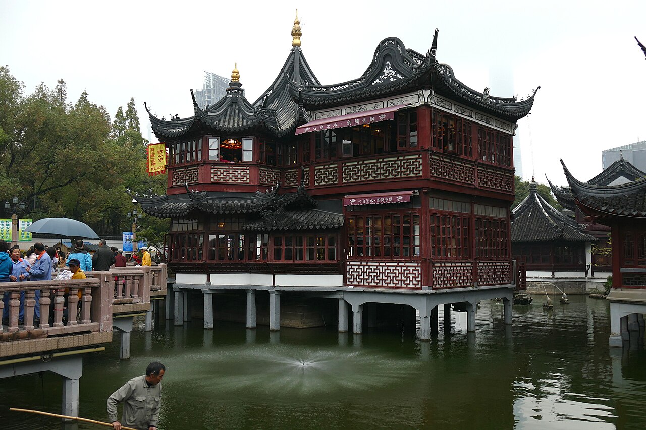 九曲桥和湖心亭，暗红色水刷石桥面和湖心亭茶楼是庙市商业的核心节点