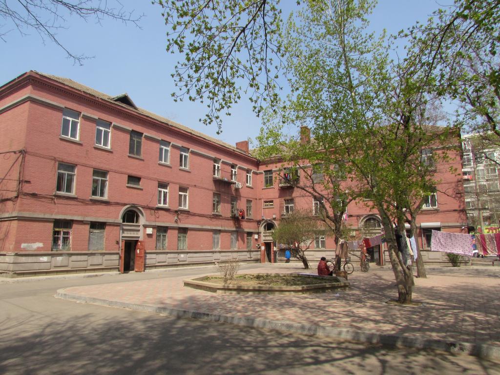 工人村红砖楼群近景，涂料剥落后露出原始红砖