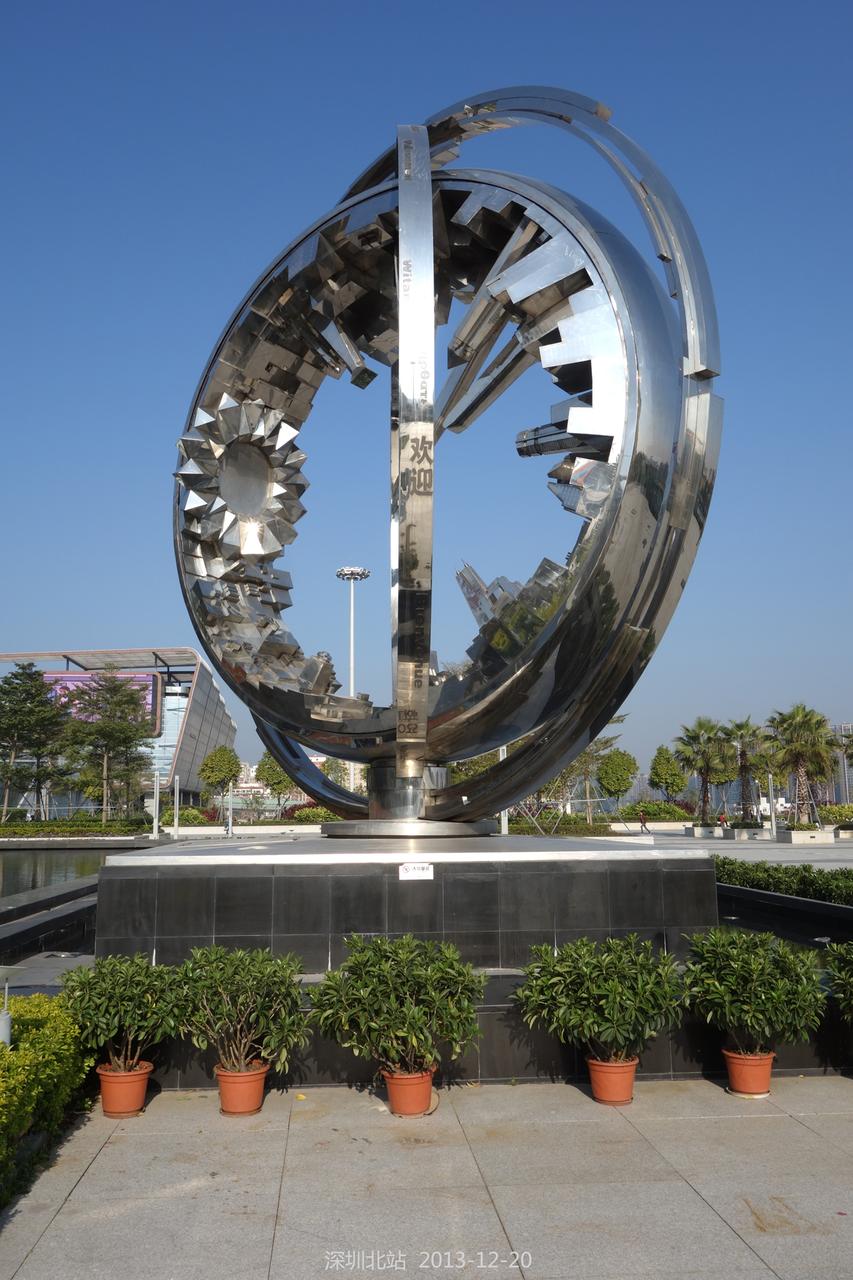 深圳北站东广场雕塑及周边城市环境，开阔的站前空间与远处新建高楼形成对比