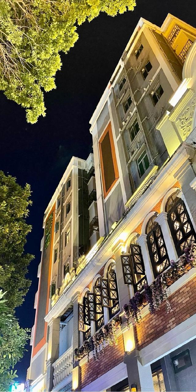 水围1368夜间建筑立面，骑楼柱廊的花箱和暖色灯光