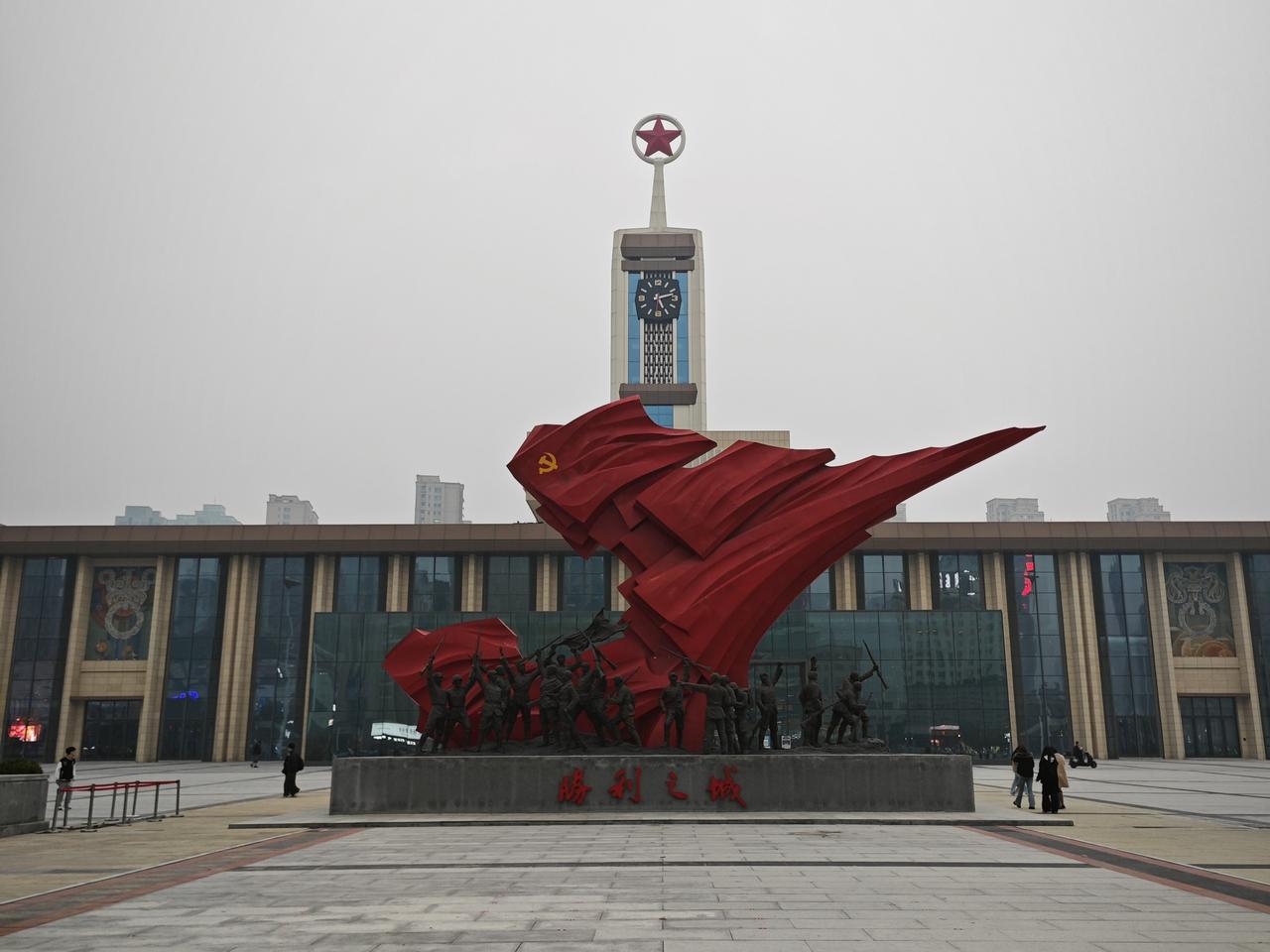 解放广场上的老火车站站房西立面，钟楼和"胜利之城"雕塑