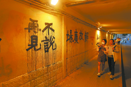 铁路入地后中山路地道桥原址填平,行人走过已消失的铁路切割线