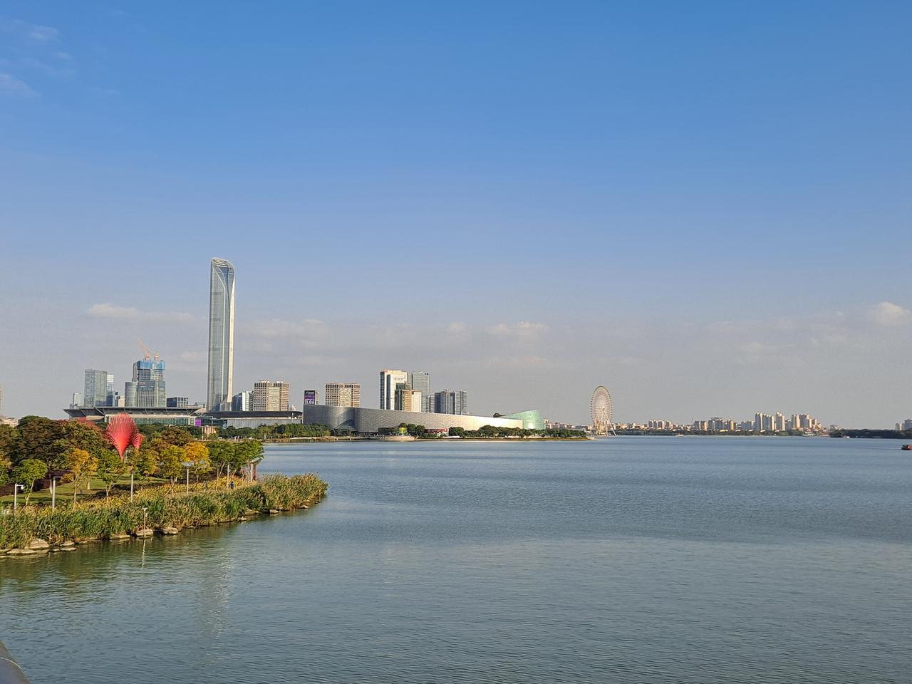 从金鸡湖岸看湖面与工业园区天际线，水面和超高层建筑群来自同一份规划