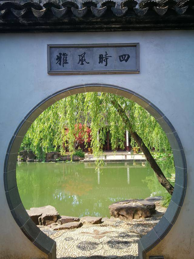可园小西湖畔的圆窗，透过窗洞可见池水与建筑