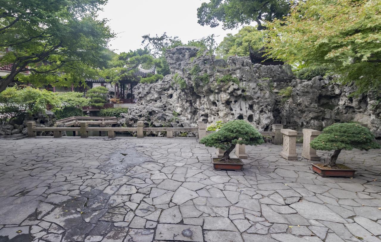 环秀山庄假山主峰：太湖石叠成的峭壁临池而起，高过两层的屋檐