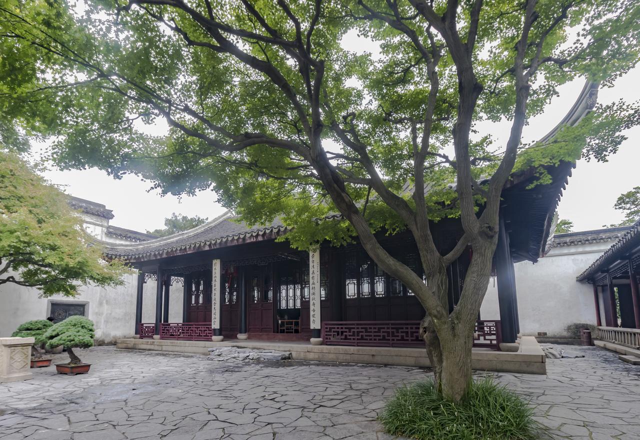 大斧劈法的竖纹石壁：太湖石以纵向纹理排列，模拟山水画中的峭壁皴法