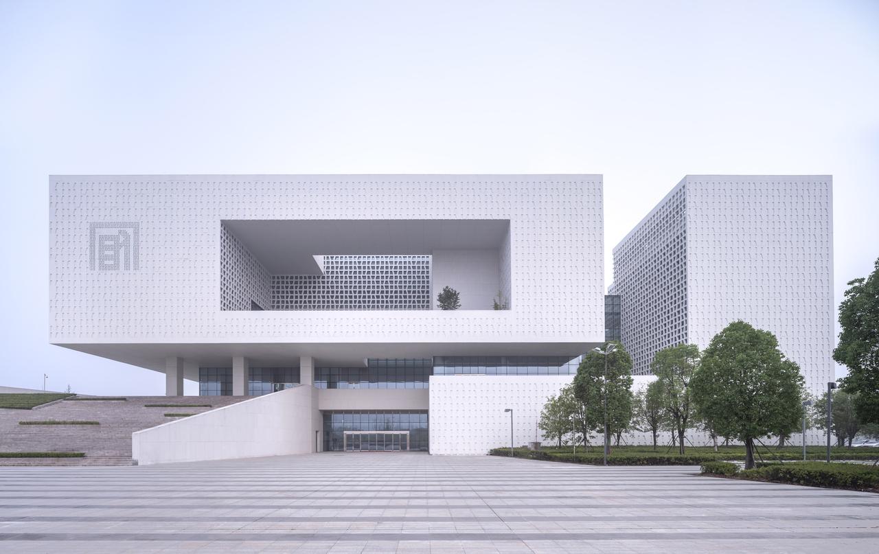 展示馆东立面，白色穿孔铝板包裹的现代建筑