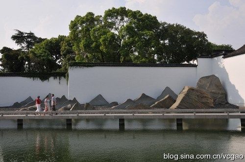 主庭院的水面、石桥和八角亭，远处可见"中国黑"花岗岩屋顶