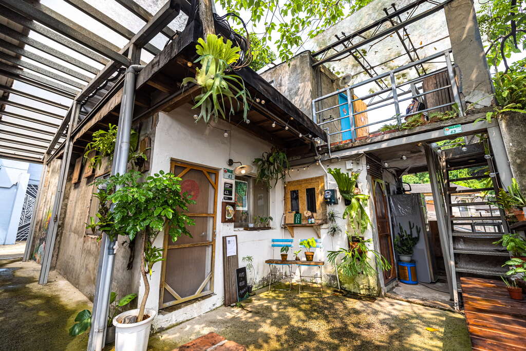 A small, rustic artist village with a white-washed building adorned with numerou