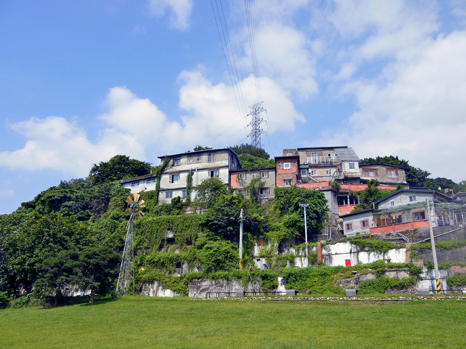 宝藏岩聚落的房屋群，低矮的铁皮屋顶和砖墙建筑依山而建