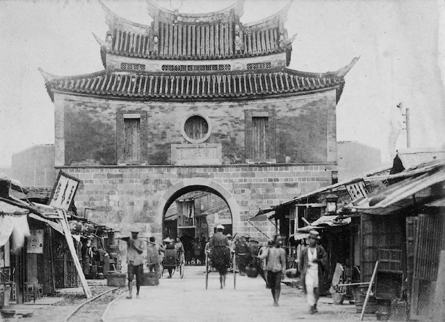台北西门(宝成门)历史照片，歇山重檐城楼，门前可见铁轨和行人