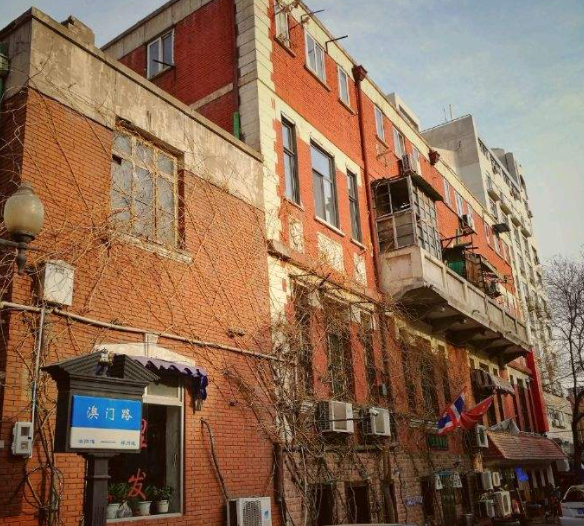周学熙旧居外观，红砖与浅色抹灰交替的三层西式住宅
