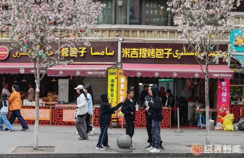 山西巷街景，两旁为维汉双语招牌的店铺，传统铜器、乐器店在营业