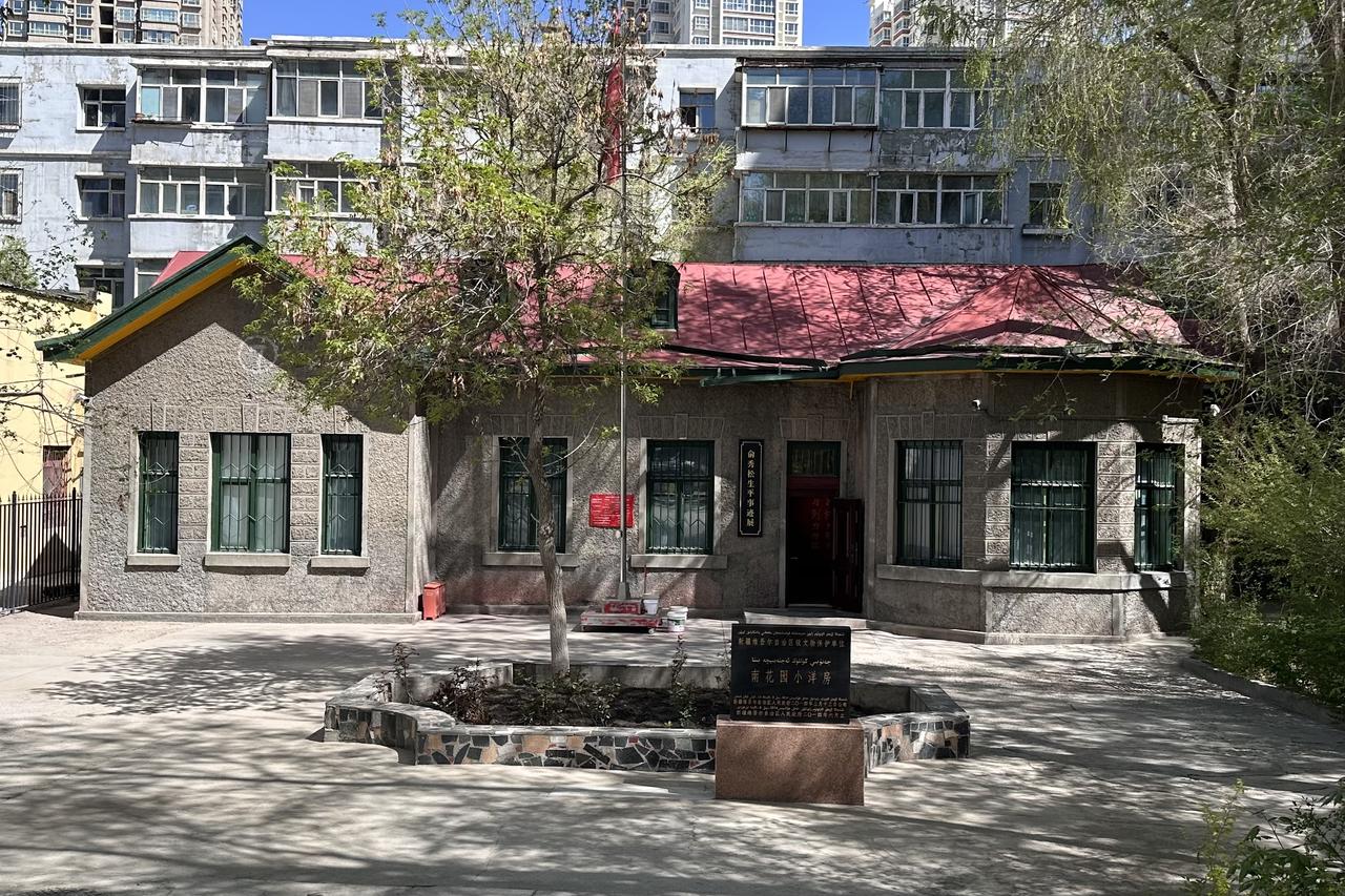 南花园小洋房外观，一栋红顶黄墙的俄式风格小楼，夹在现代高层建筑之间