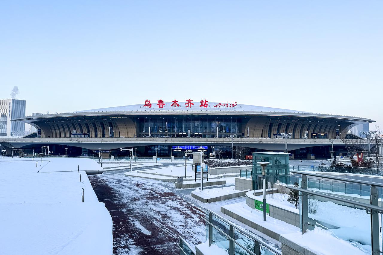 乌鲁木齐站外景，梭子形站房和弧形屋顶，暖黄色外立面