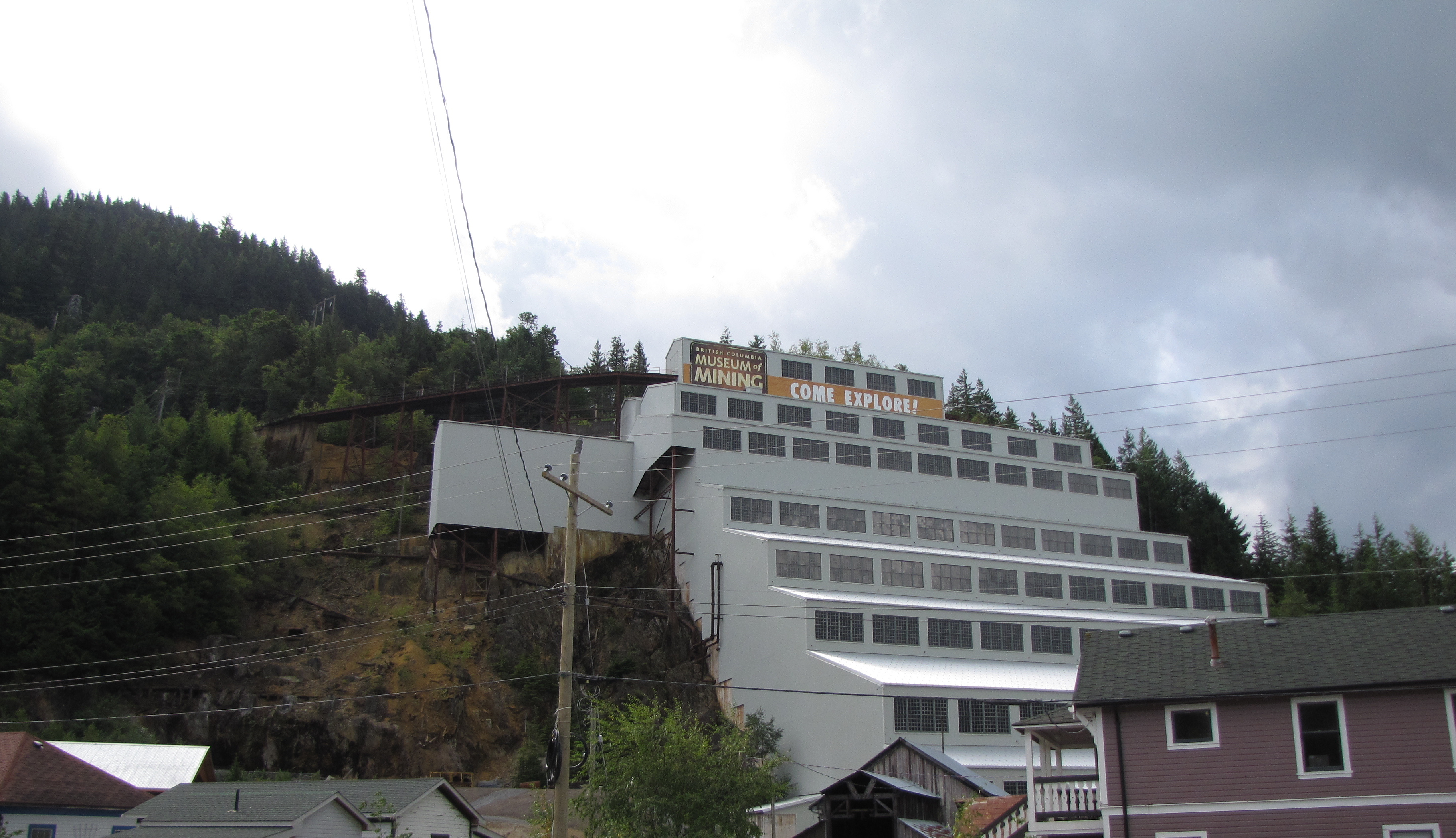 Mill 3 二十层钢筋混凝土选矿厂外观，阶梯状结构嵌在 Mount Sheer 山体中，从山脚延伸到山腰