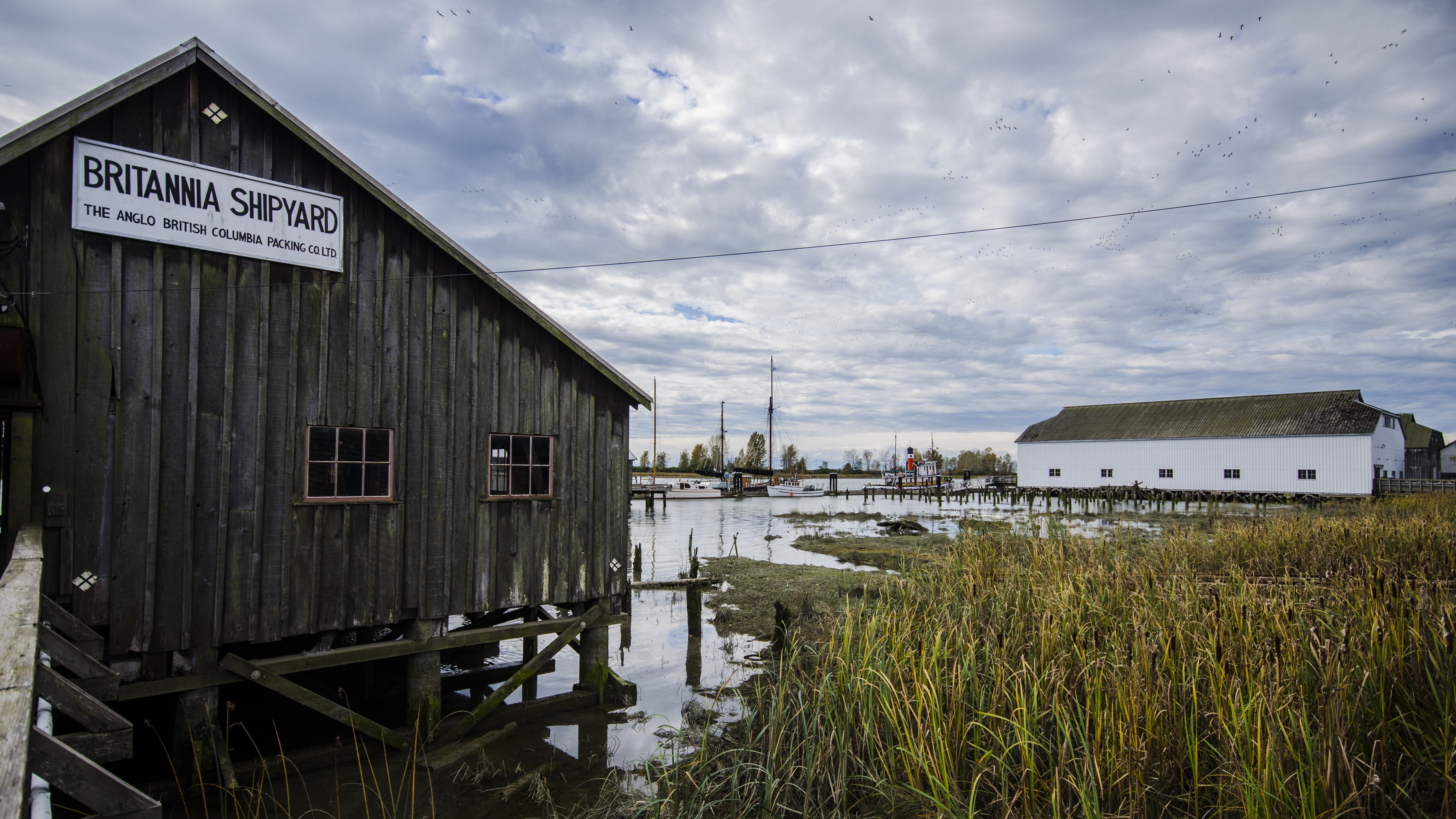 Britannia Shipyard 主建筑，L 形木结构厂房，船台滑道开口记录着转型痕迹