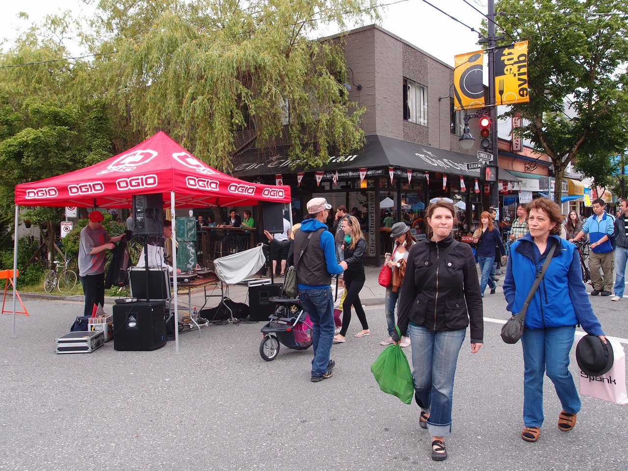 2011 年 Car-Free Vancouver Day 期间 Commercial Drive 街面被行人、帐篷和摊位占据，汽车让位给社区活动