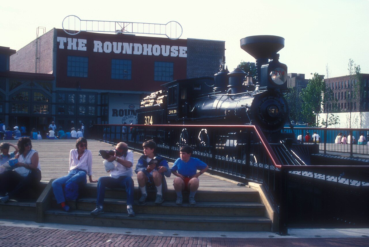 Expo 86 期间的 Roundhouse，半圆形砖建筑与周边展区，背景可见 False Creek 和北岸