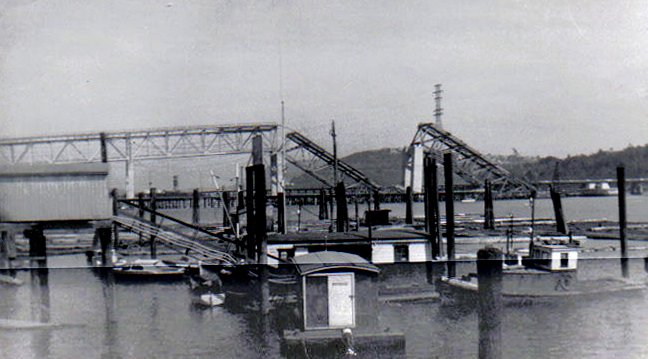 1958 年 8 月 17 日拍摄，坍塌后两个月的 Second Narrows Bridge，未完成桥跨的缺口和临时支撑残骸清晰可见
