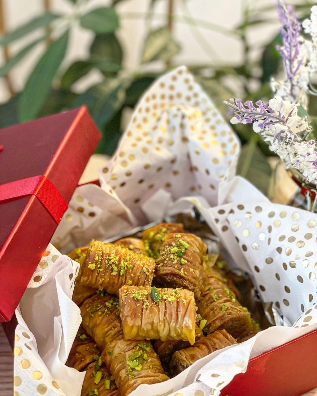 North Shore Tourism Persian Trail 页面中的波斯甜点图片，盒中 baklava 与开心果碎展示主街商业中的日常食品节点
