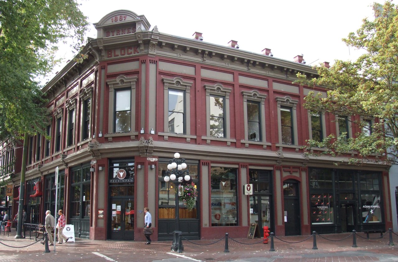 Byrnes Block 立面：两层维多利亚 Italianate 砖楼，半圆拱窗、檐口托饰、对称双开间