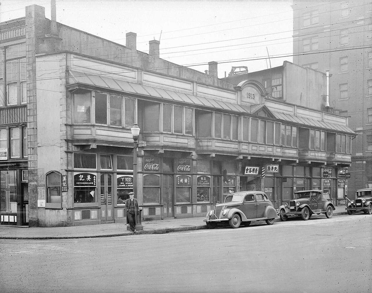 1937 年 Pender Street at Carrall 街角的 Sam Kee Building，窄楼夹在街角商业建筑之间