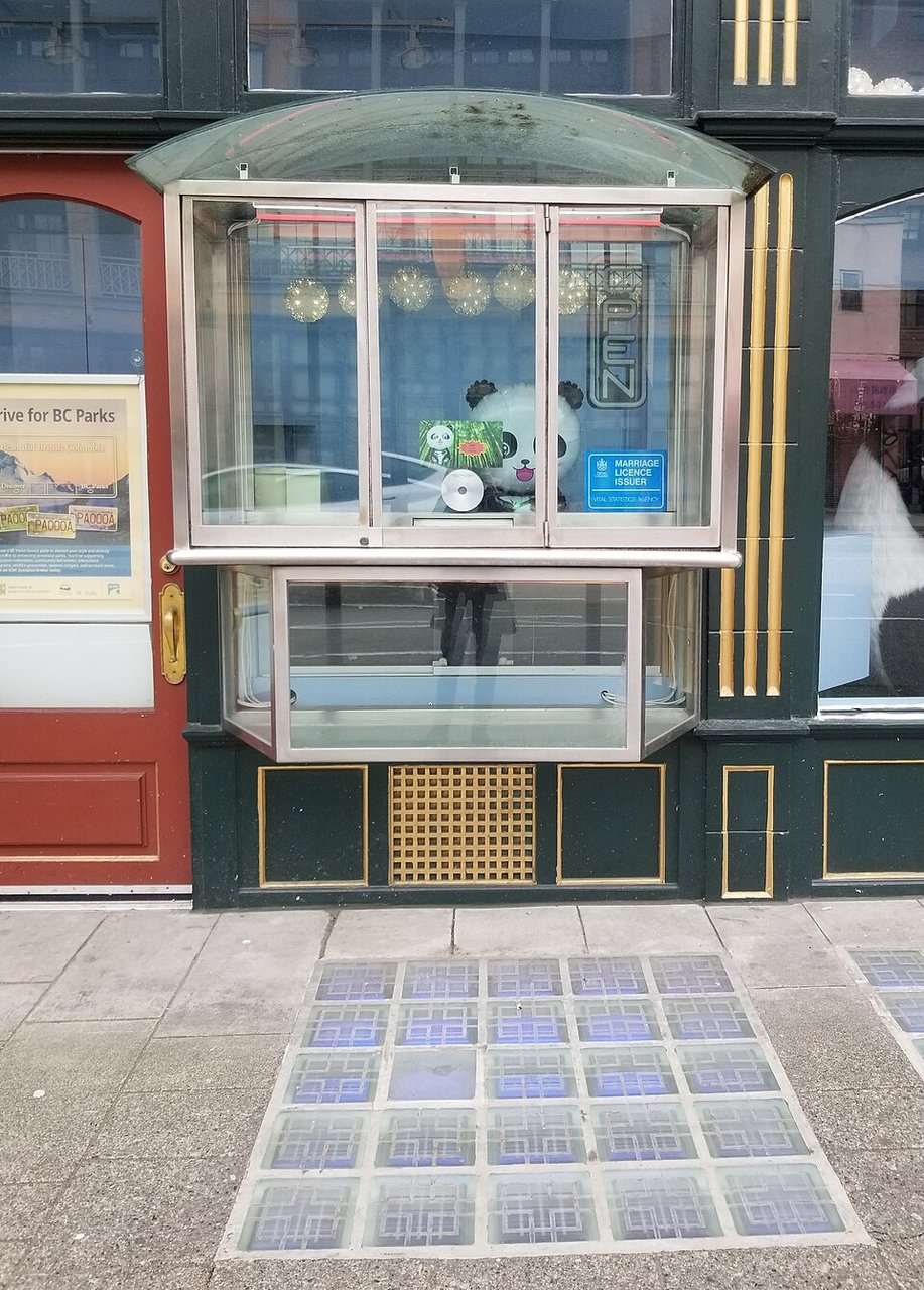 Sam Kee Building 店面前的人行道玻璃块和玻璃窗口，玻璃块沿店面外侧排列