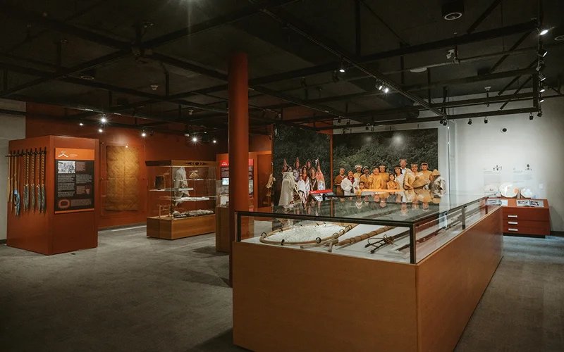 SLCC Gallery 内部展陈，包含 weavings、regalia 和 spindle whorls 等物件