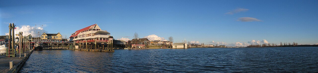 从 Fisherman's Wharf 看 Steveston Village 与弗雷泽河南支流，渔港、木栈道和村镇同框