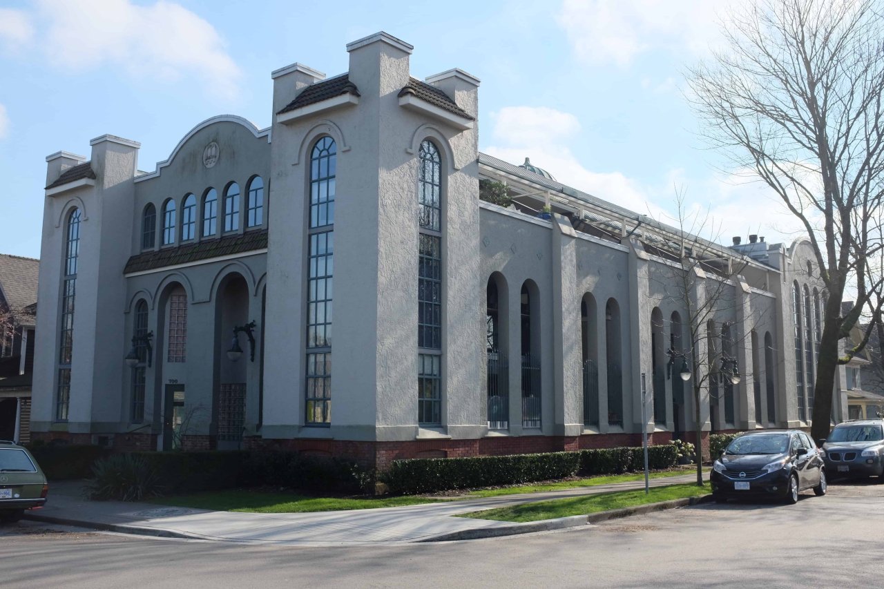 700 East Pender 旧 Schara Tzedeck 会堂现状外立面，拱窗和街角体量可见，入口已改为公寓门禁