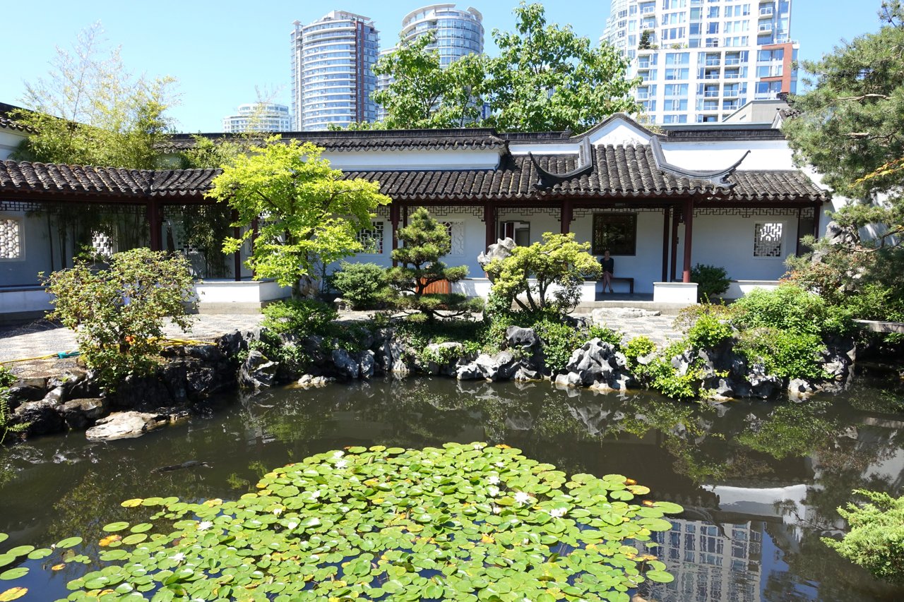 水池倒映周围城市建筑轮廓，可以看到苏州园林的亭台和北美城市建筑线同时出现在水面上